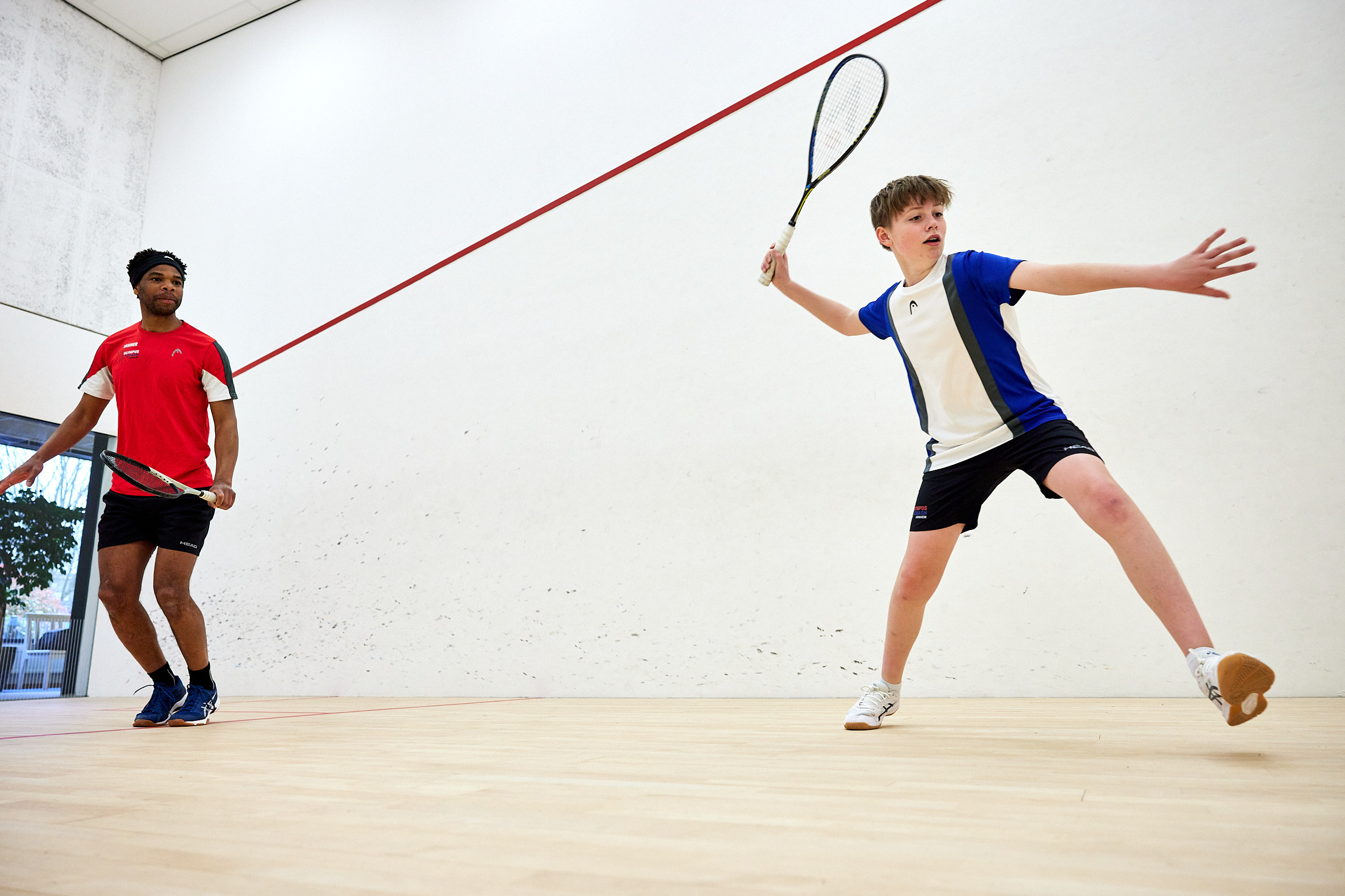 afbeelding met squashers op de squashbaan